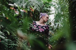 Junge Frau mitten in Pflanzen in einem Gewächshaus 