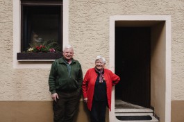 Altes Ehepaar steht vor ihrem Haus in der Pfalz 
