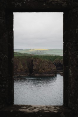 Blick aus einem Fensterrahmen auf die schottischen Highlands 