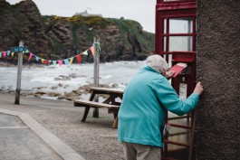 Alte Frau wirft Post in Briefkasten 