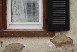 Fenster mit Vorhängen und Fensterläden in einem Dorf in der Pfalz 